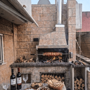 Συγκρότημα σύνθεση χτιστής ψησταριάς με πάγκο στο πλαϊνό της και επένδυση από πέτρα.